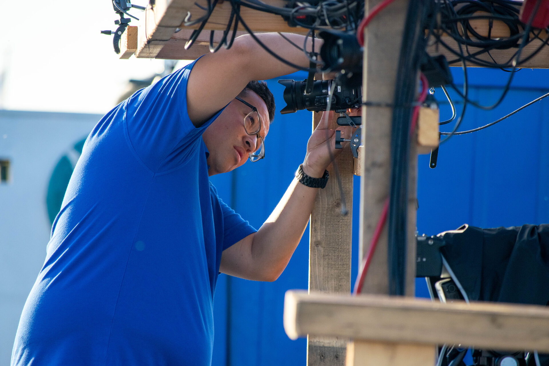 Crewlid monteert een camera hoog in de constructie van het uitzendschip