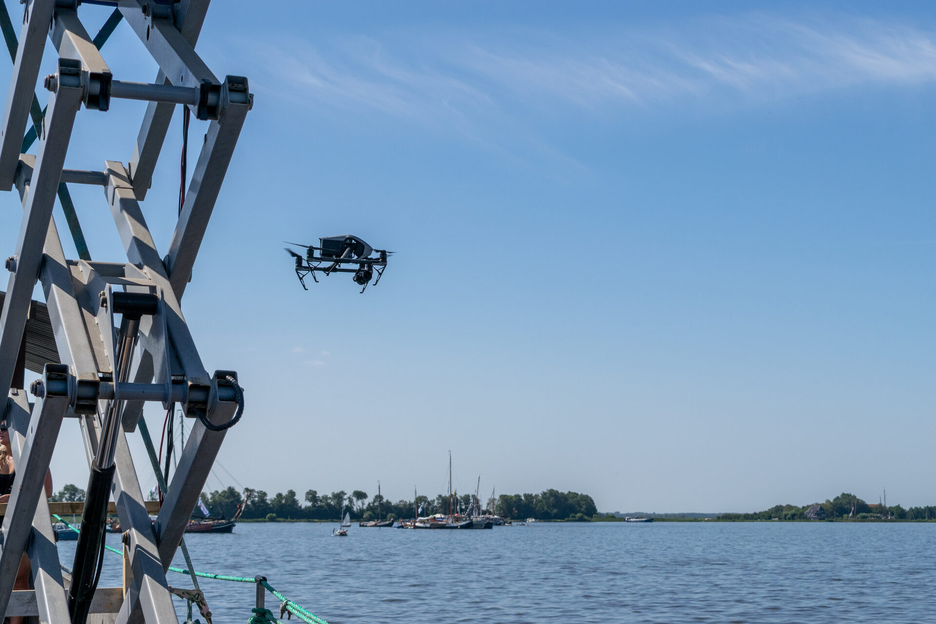 De drone stijgt op naast de hoogwerker op het uitzendschip