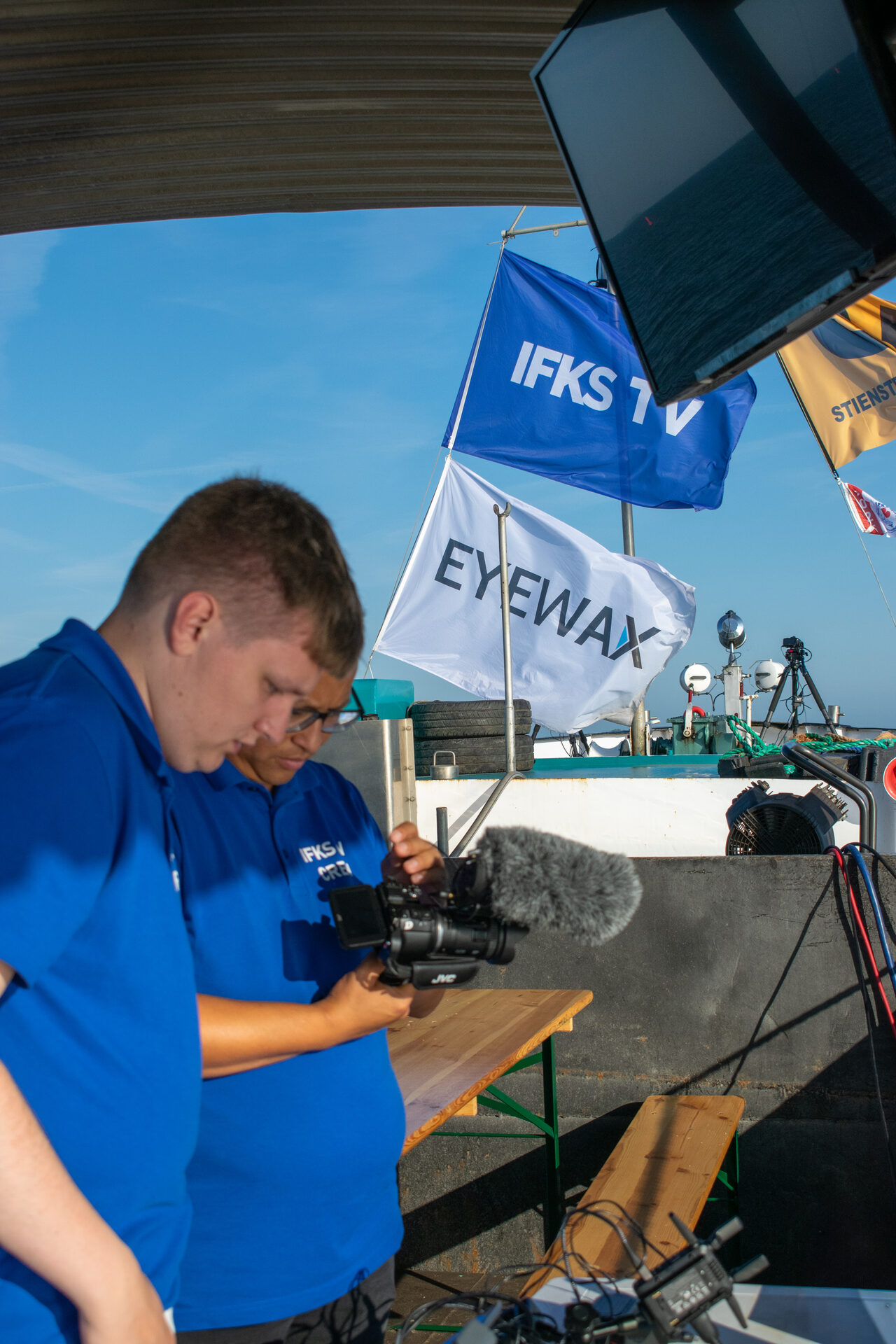 Cameraman onder de vlaggen van IFKS TV en Eyewax